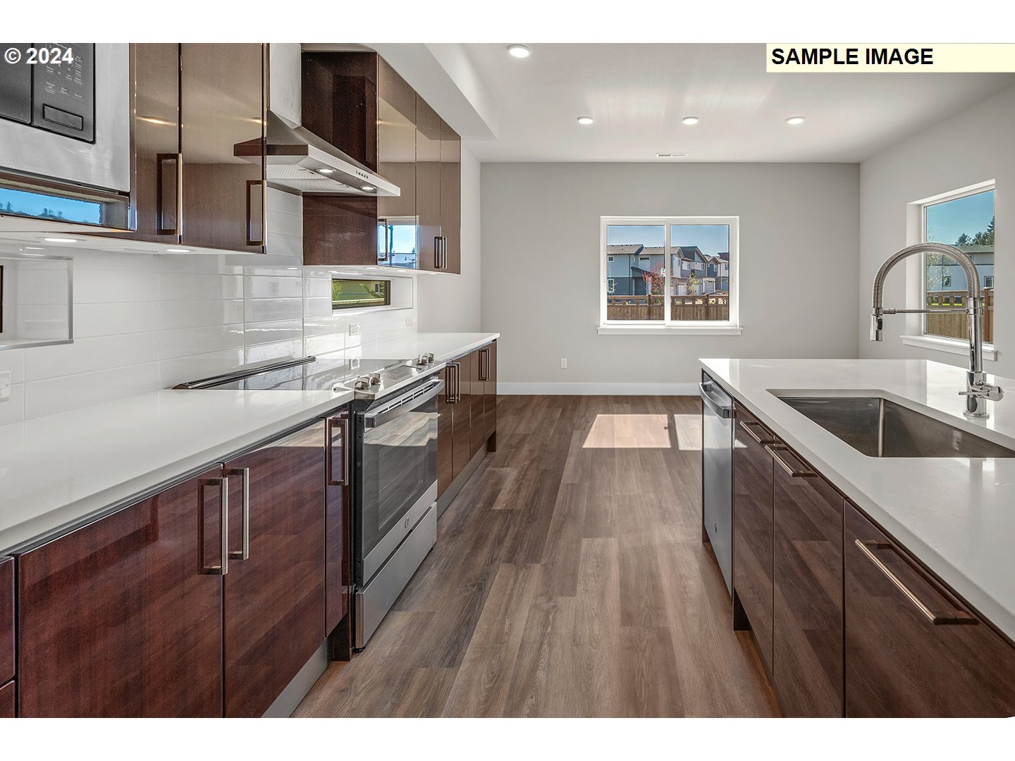 12343 Southeast Falling Rain Way Happy Valley, OR 97086 - Photo 13 of 39 a kitchen with kitchen island granite countertop a sink cabinets and wooden floor