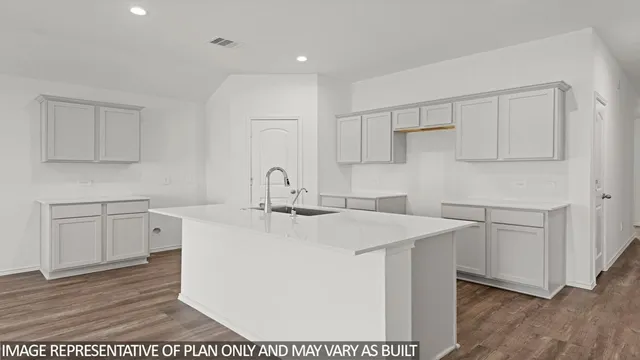 a kitchen with sink a microwave and cabinets