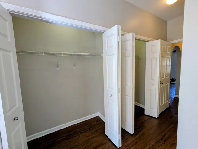 a view of walk in closet with wooden floor