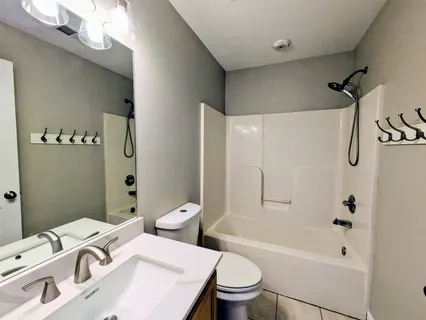 a white toilet sitting next to a bath tub