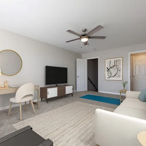 a living room with furniture a flat screen tv and kitchen view