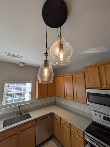 a kitchen with a sink and chandelier