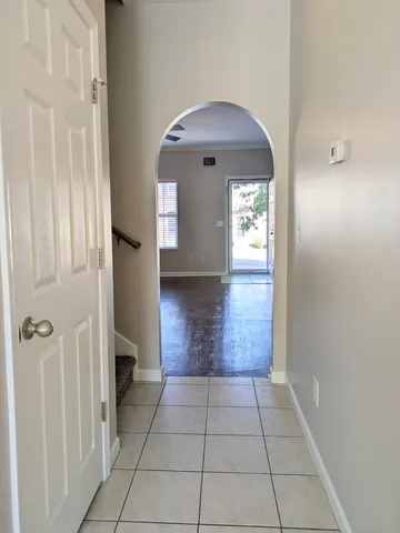 a view of a hallway with wooden floor and a living room