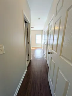 a view of a hallway with wooden floor and staircase