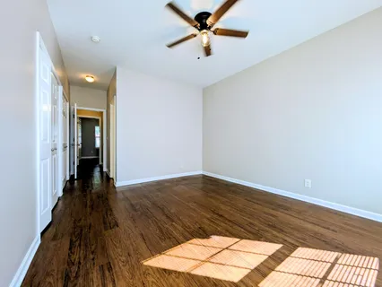 a view of a livingroom with wooden floor and a ceiling fan