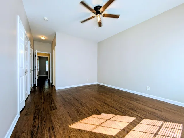 a view of a livingroom with wooden floor and a ceiling fan