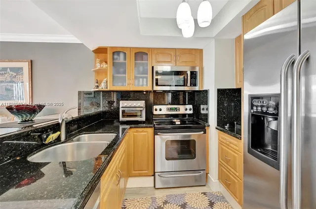 a kitchen with stainless steel appliances a refrigerator sink and microwave