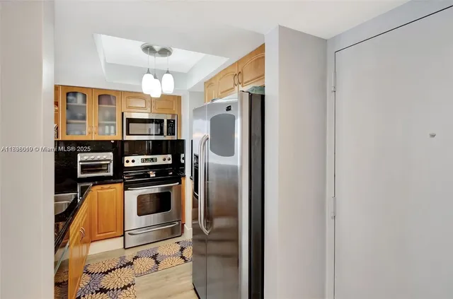 a view of a dining room with furniture a kitchen and chandelier