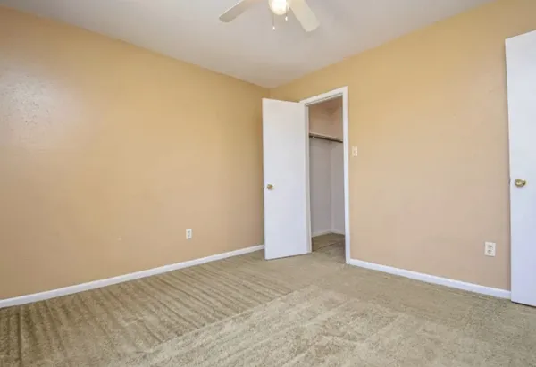 an empty room with a ceiling fan and a window