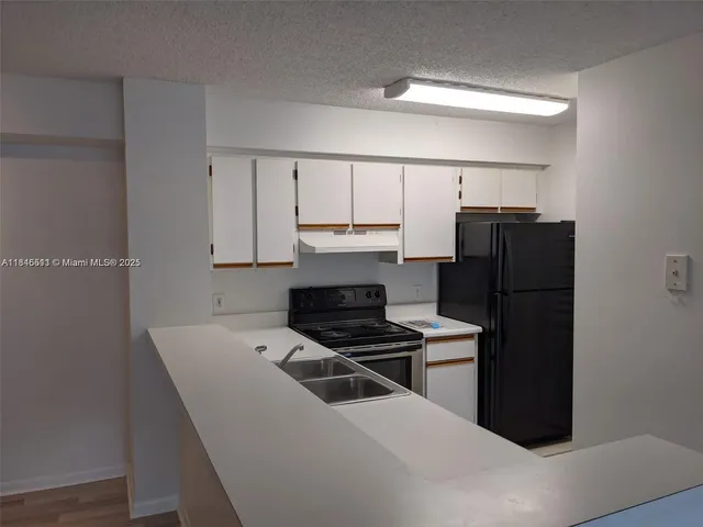 a kitchen with a refrigerator and a stove top oven