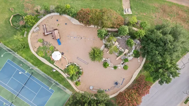 an aerial view of a house with a yard and greenery
