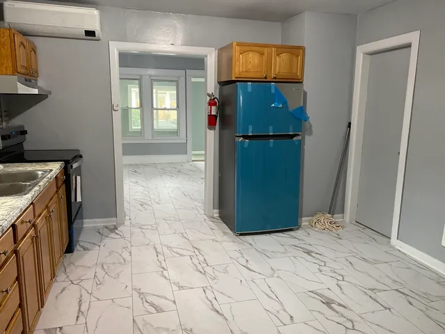 a view of empty room with cabinet and wooden floor