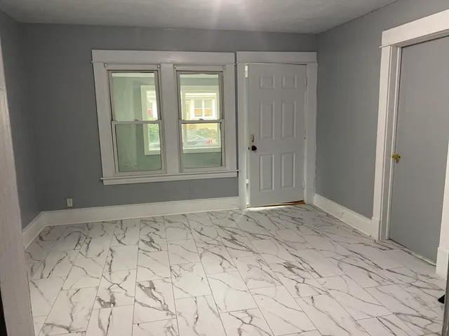 a view of empty room with window and closet area