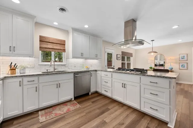 a kitchen with granite countertop white cabinets white stainless steel appliances a sink and a window
