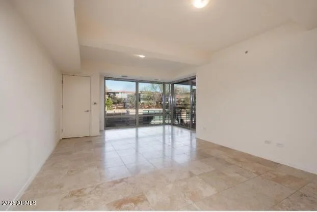 an empty room with floor to ceiling window and an outdoor view