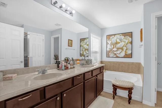 a bathroom with a granite countertop sink a mirror and a bathtub