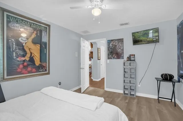 a bedroom with a bed and a painting on the wall