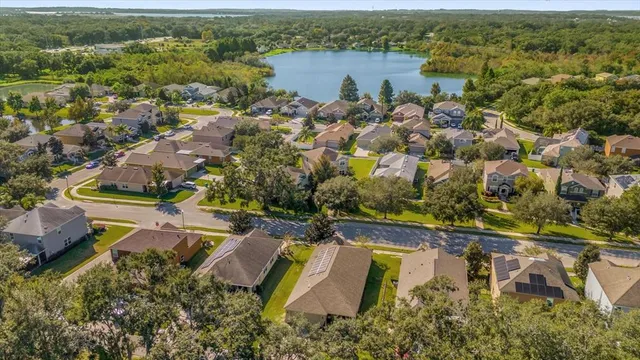 an aerial view of residential houses with outdoor space and lake view