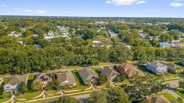 an aerial view of residential houses with outdoor space and trees
