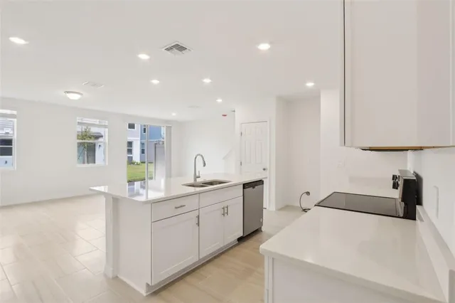a close view of a sink and dishwasher with wooden floor