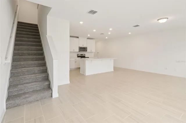 a view of a kitchen with sink and refrigerator