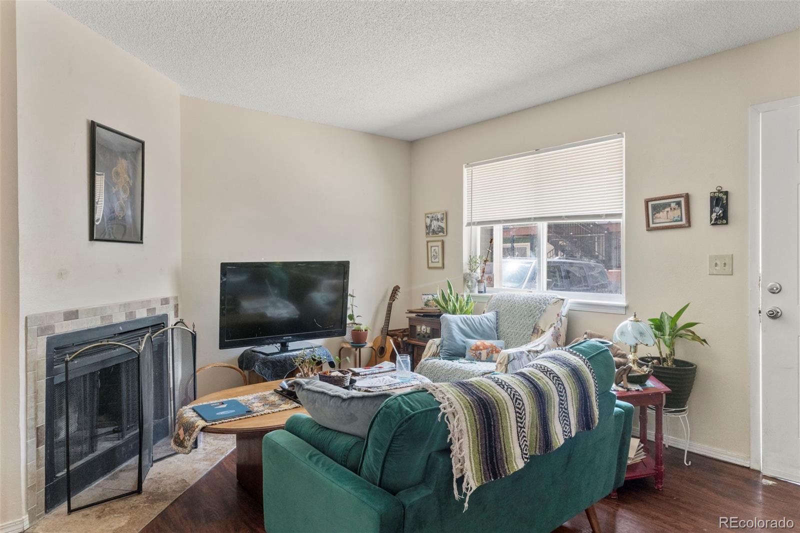 567-579 Winnie Way Colorado Springs, CO 80904 - Photo 16 of 32 a living room with furniture a fireplace and a flat screen tv