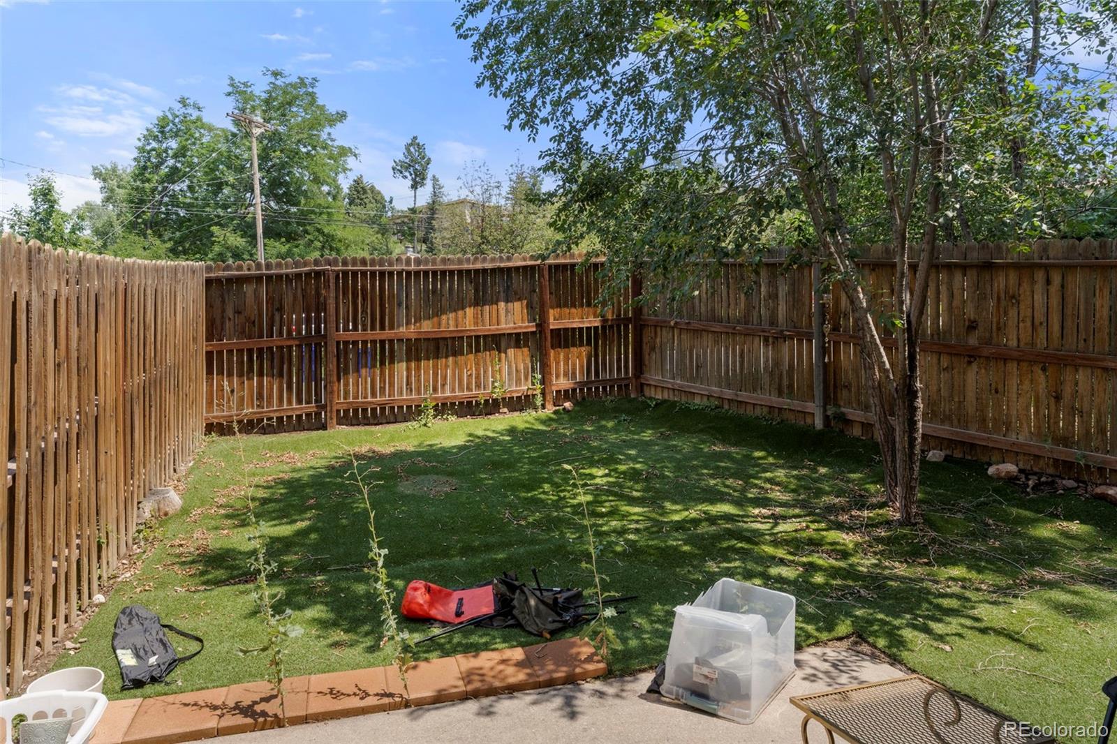567-579 Winnie Way Colorado Springs, CO 80904 - Photo 22 of 32 a backyard of a house with lots of green space and glass doors