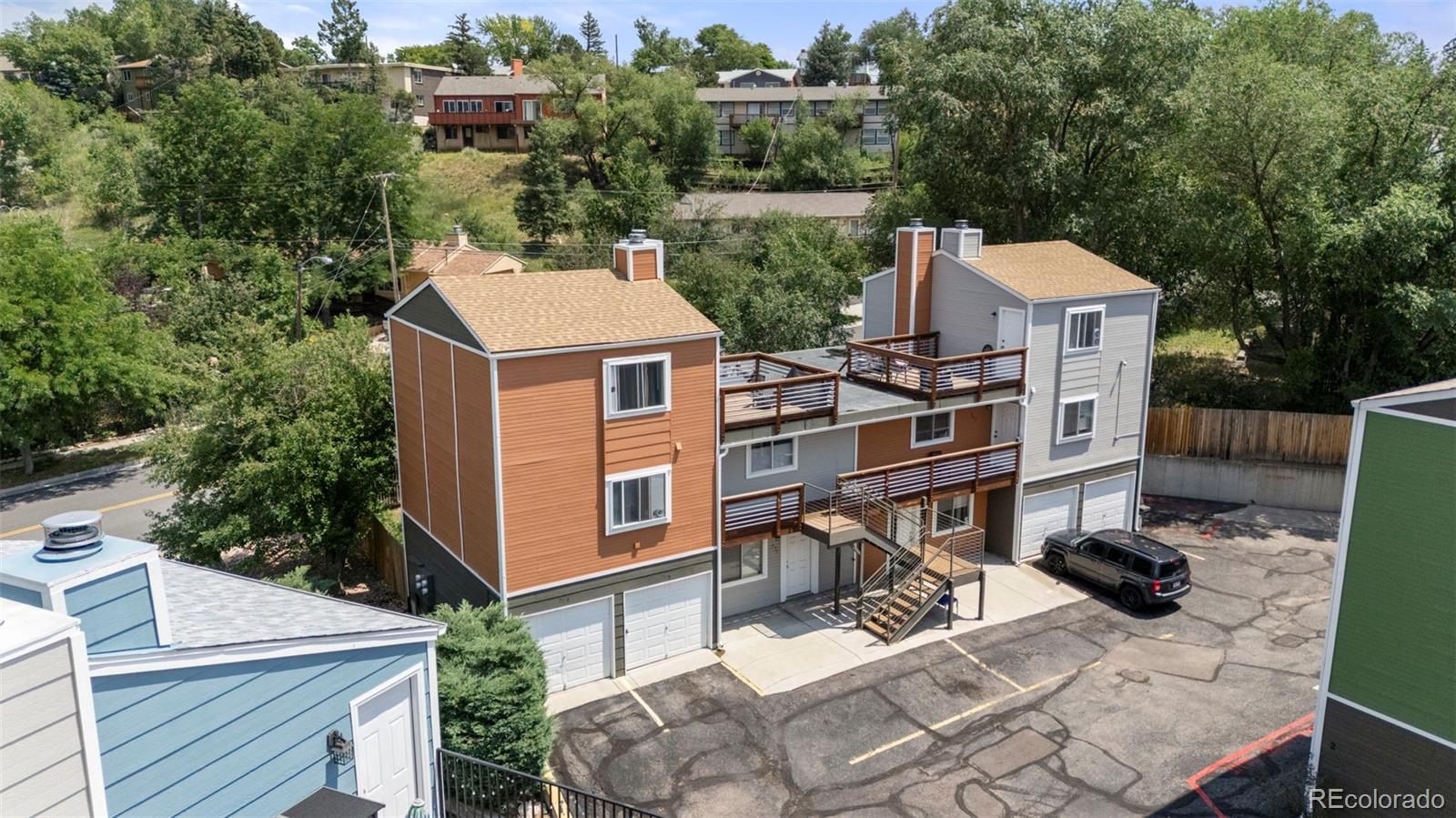 567-579 Winnie Way Colorado Springs, CO 80904 - Photo 29 of 32 a view of a patio with table and chairs with wooden floor and fence