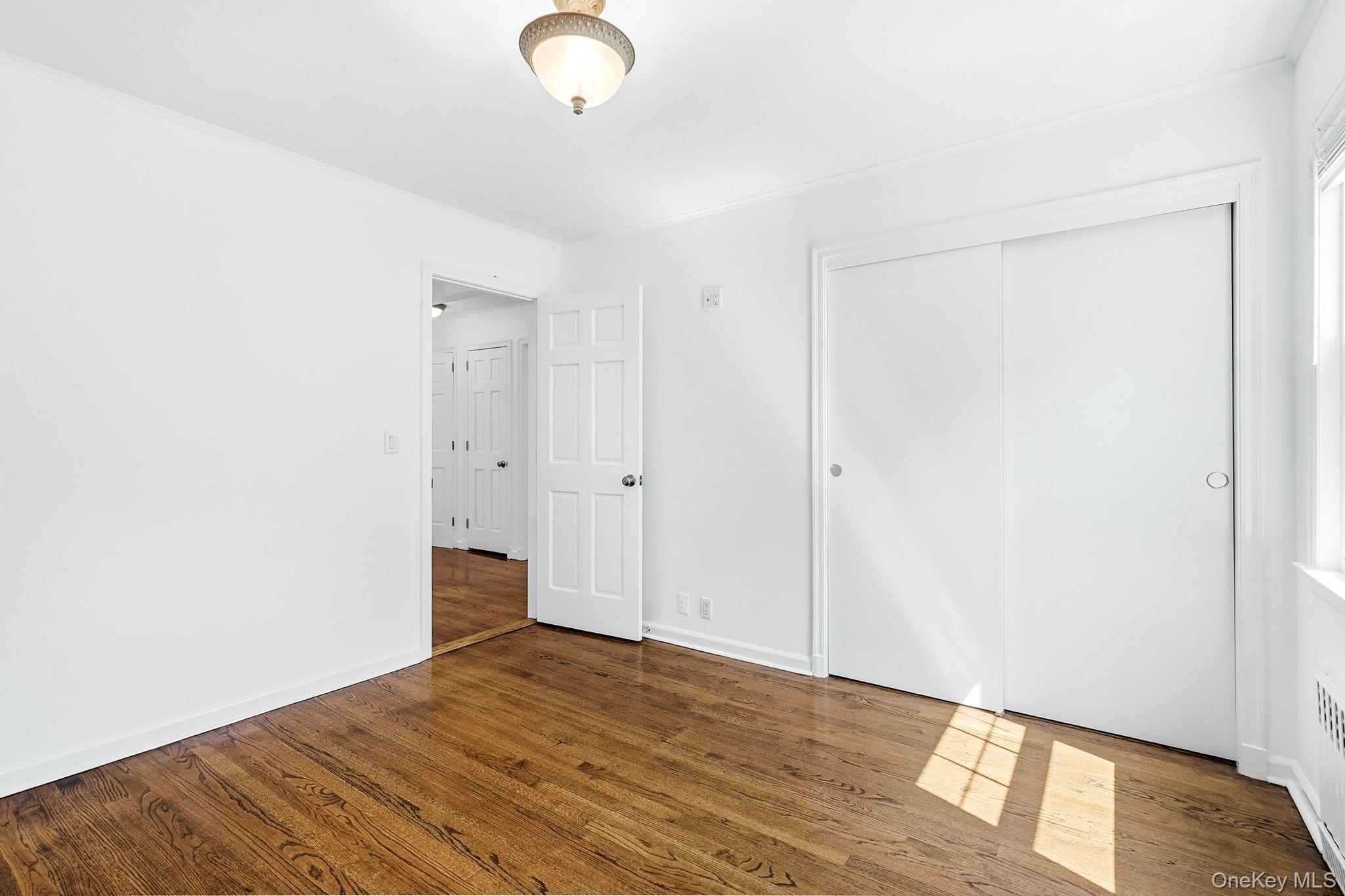 317 Hornidge Road Mamaroneck, NY 10543 - Photo 15 of 21 a view of an empty room with wooden floor and a window