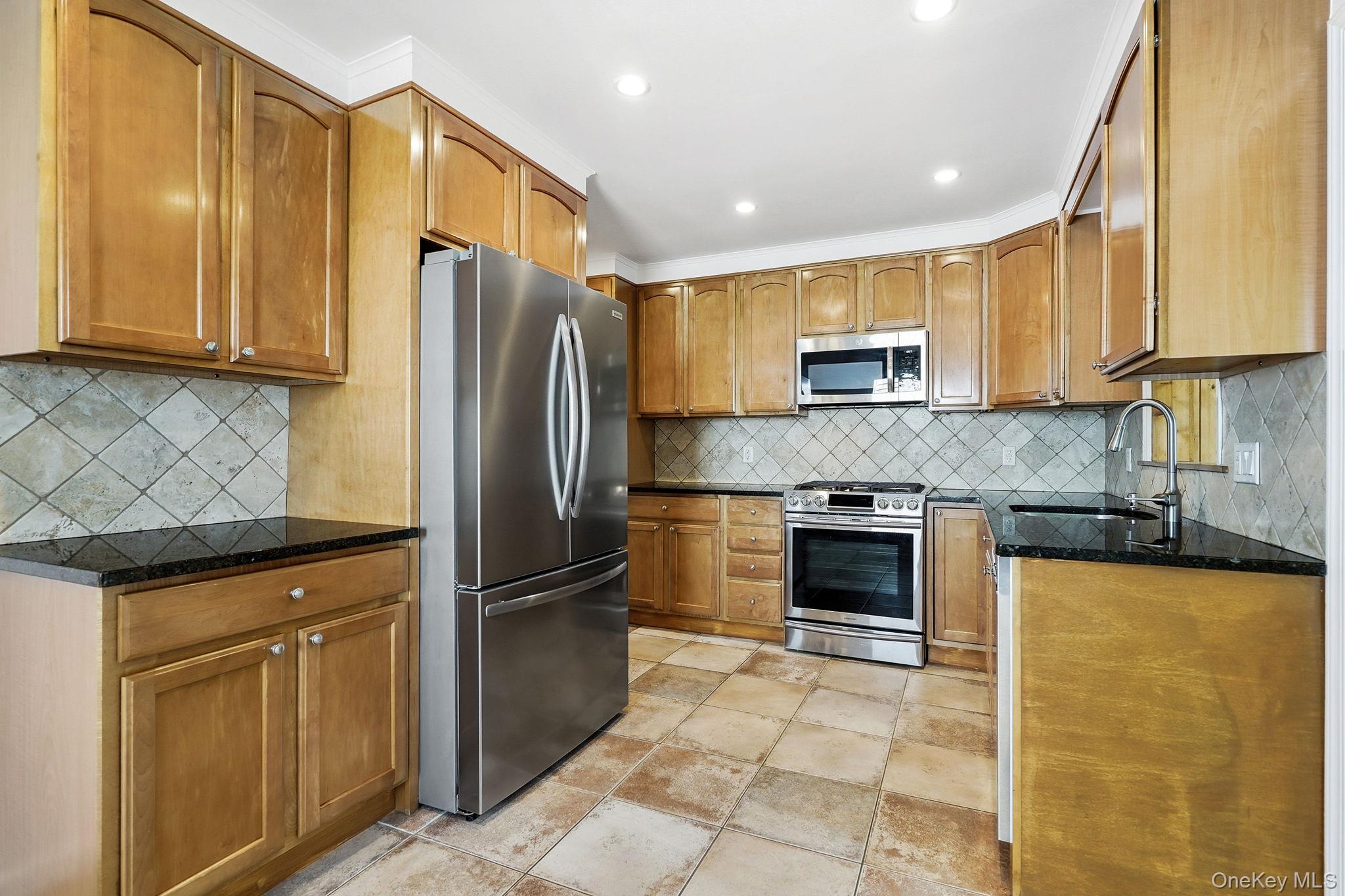 317 Hornidge Road Mamaroneck, NY 10543 - Photo 5 of 21 a kitchen with granite countertop a refrigerator and a stove top oven