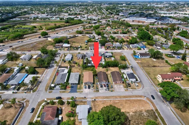 an aerial view of residential houses with outdoor space and swimming pool