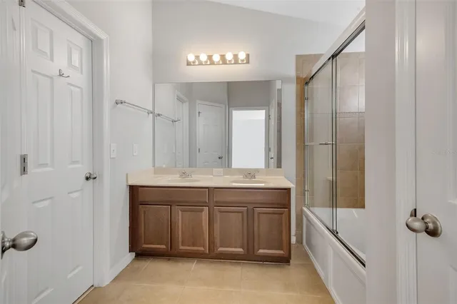 a bathroom with a granite countertop sink a mirror and a shower