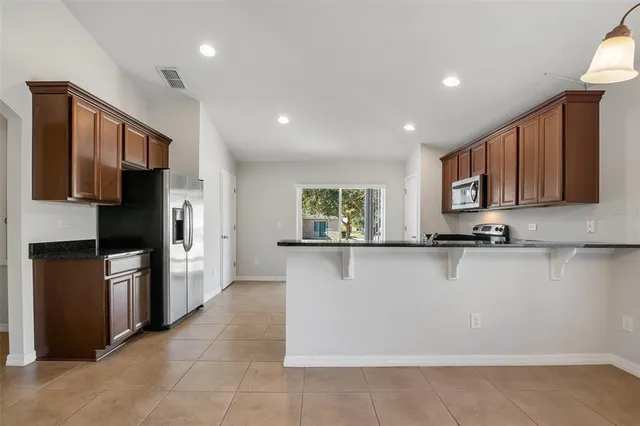 a view of kitchen with stainless steel appliances cabinets