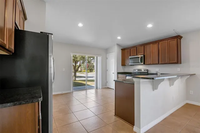 a kitchen with stainless steel appliances granite countertop a refrigerator and a stove top oven
