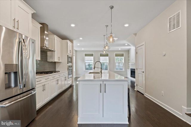 a kitchen with stainless steel appliances granite countertop a refrigerator and a stove top oven