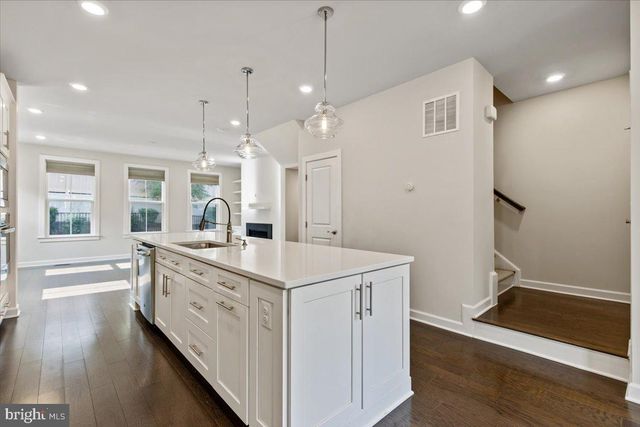a large white kitchen with a sink a refrigerator and a stove