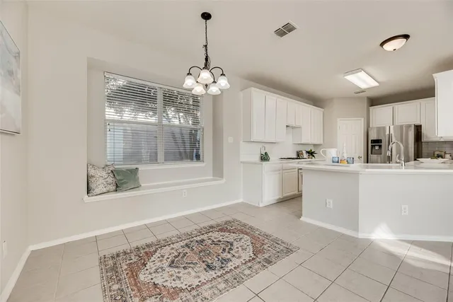 a kitchen with stainless steel appliances kitchen island granite countertop a refrigerator a stove a sink dishwasher and white cabinets with wooden floor