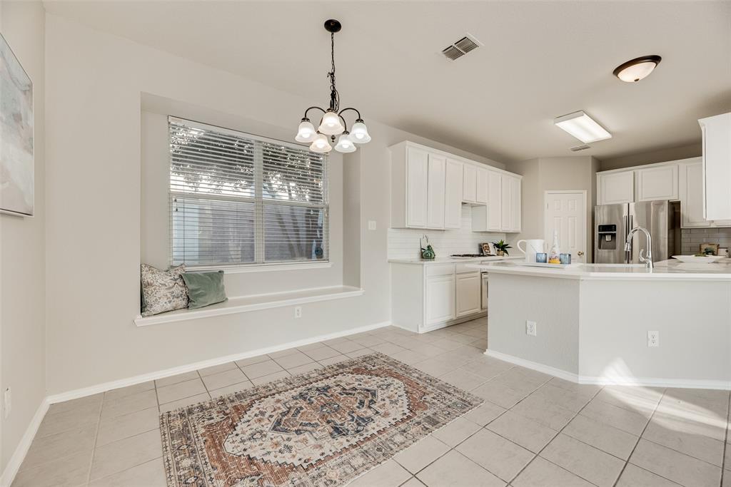 4404 Ridge Point Lane Plano, TX 75024 - Photo 5 of 18 a kitchen with stainless steel appliances kitchen island granite countertop a refrigerator a stove a sink dishwasher and white cabinets with wooden floor