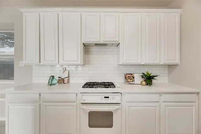 a kitchen with white cabinets and white appliances