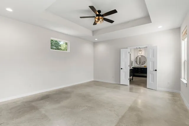 an empty room with closet and a ceiling fan