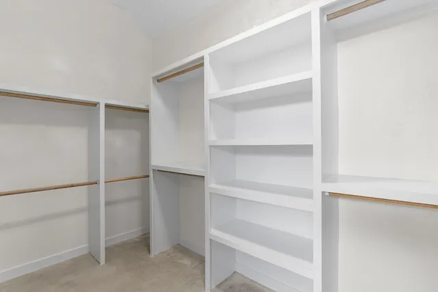 a view of walk in closet with empty racks