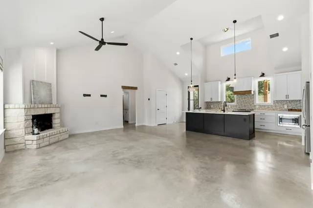 a view of a kitchen with kitchen island stainless steel appliances wooden floor and living room view