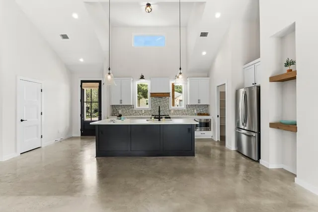 a large kitchen with a large counter top appliances and cabinets