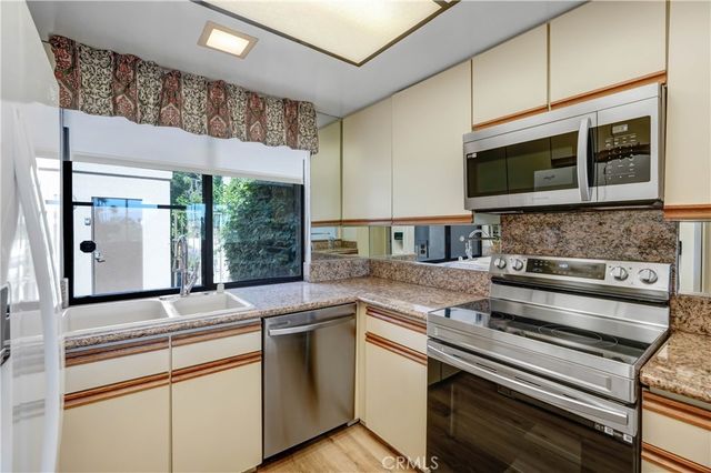 a kitchen with stainless steel appliances granite countertop a stove and a microwave
