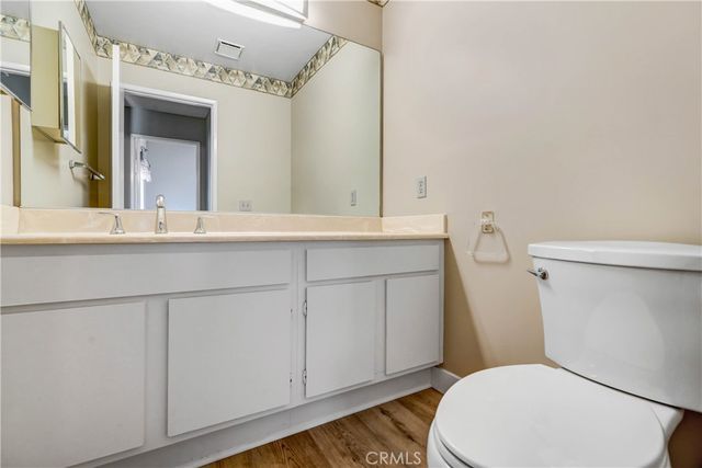 a bathroom with a sink a toilet a mirror and vanity