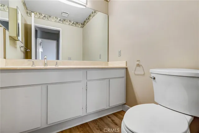 a bathroom with a sink a toilet a mirror and vanity