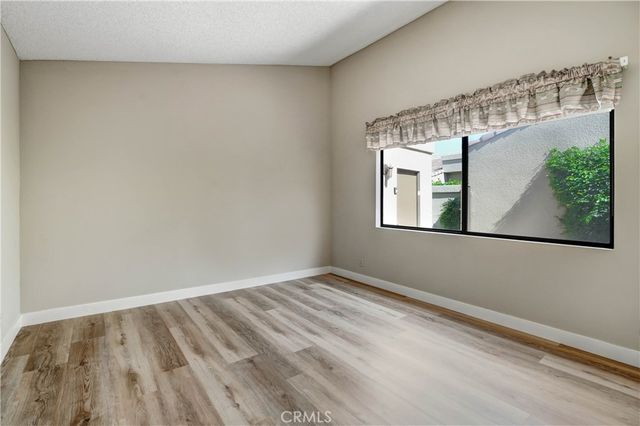 a view of a small space with wooden floor and a window