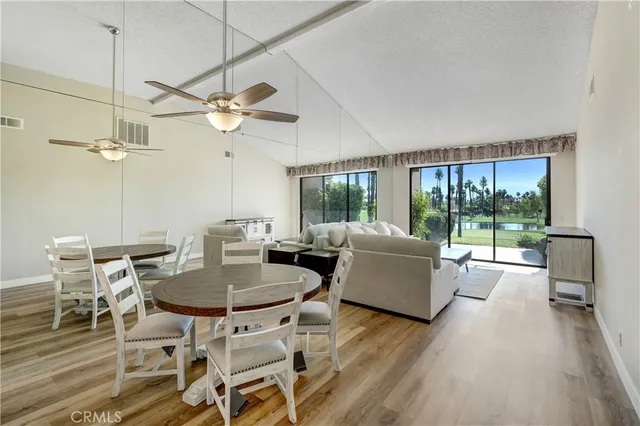 a dining room with wooden floor a chandelier a glass table and chairs