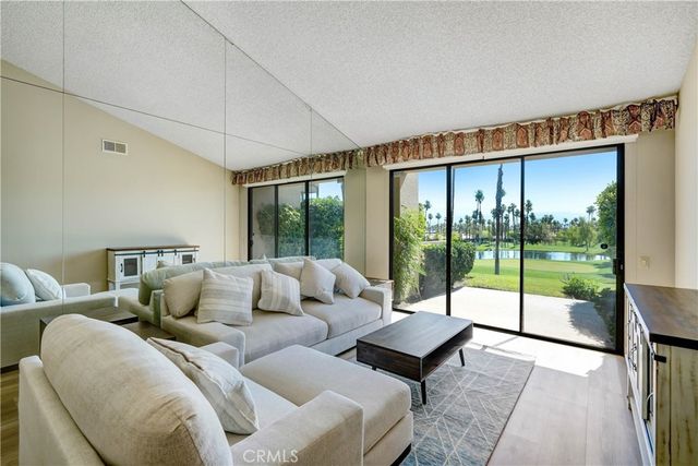 a living room with furniture and a floor to ceiling window