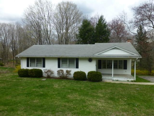 a view of a house with backyard garden and trees